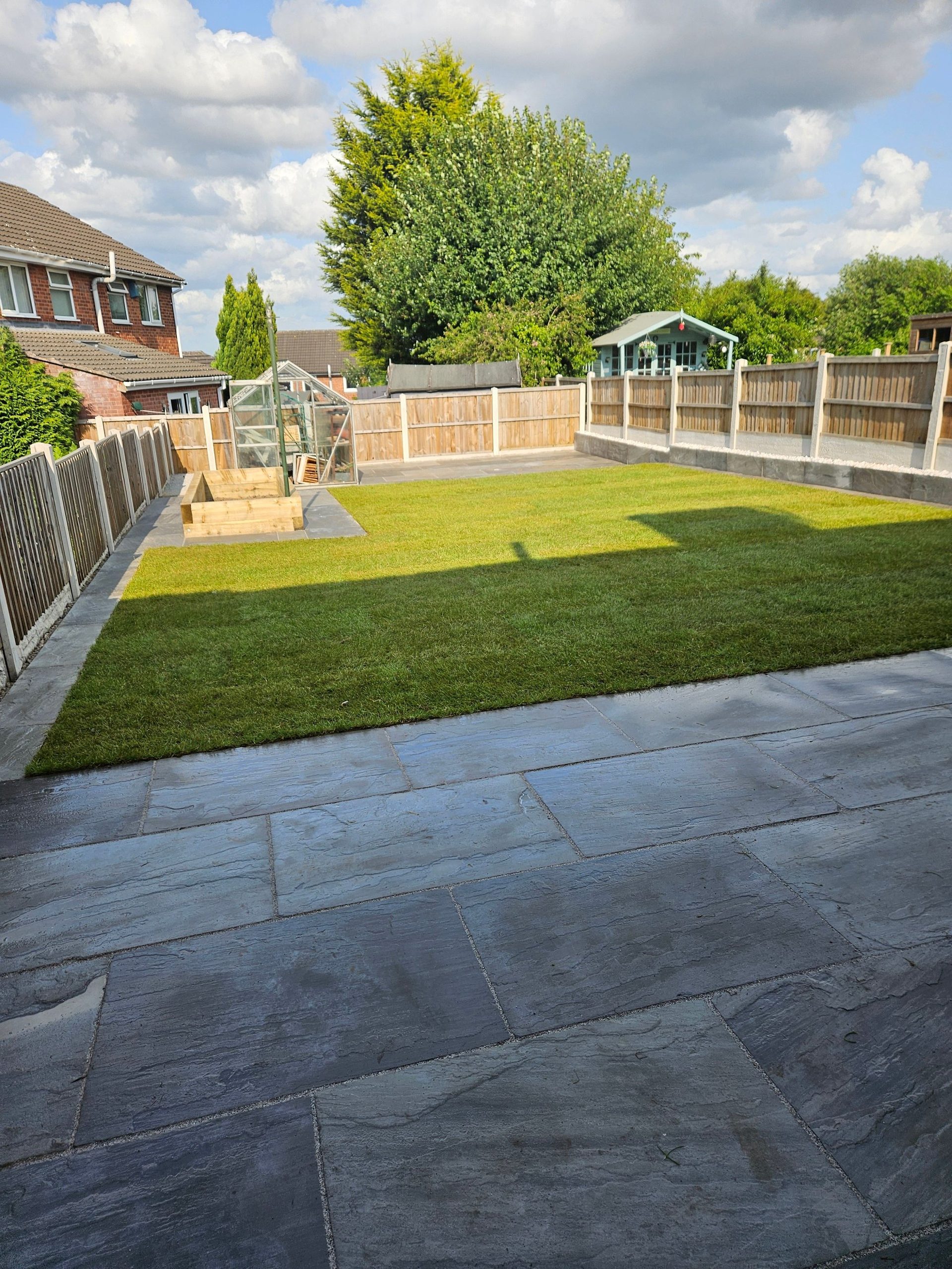 Sandstone patio with manicured lawn — landscaping aftercare on a South Yorkshire garden